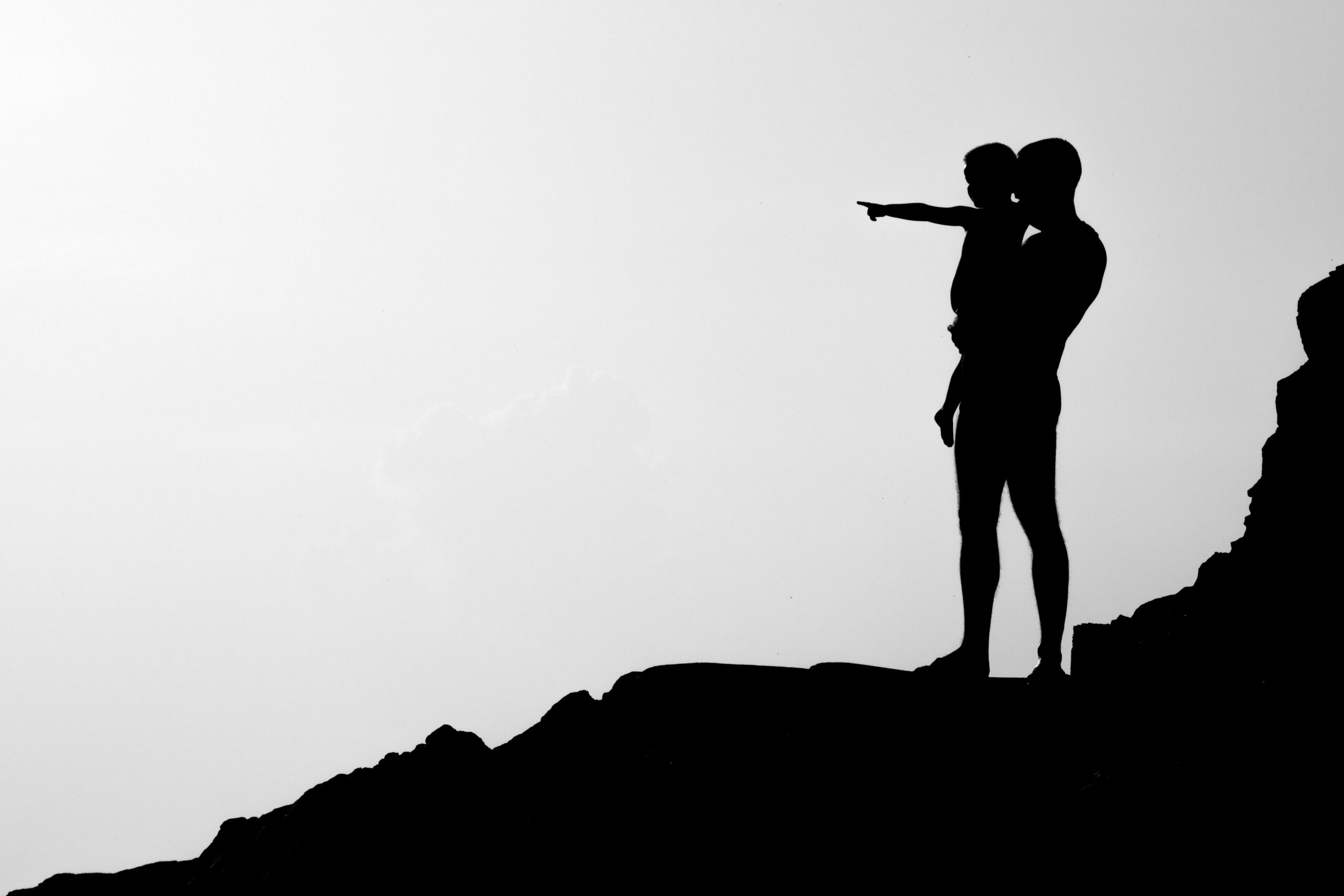 “Silhouetted parent and child standing together, evoking intergenerational connection and cultural grounding.”