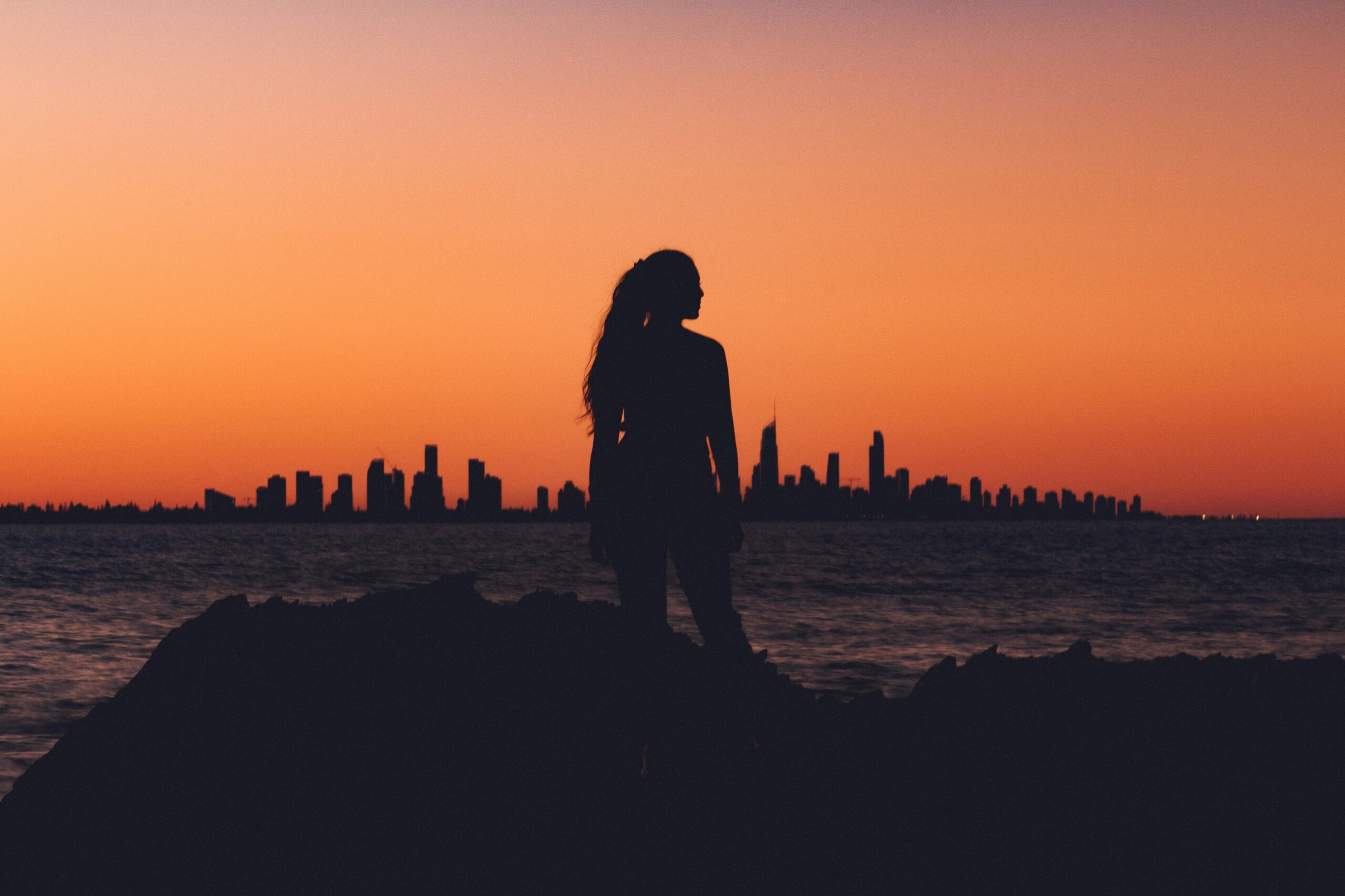 Silhouette of a woman standing on a ridge at sunset, symbolizing clarity, reflection, and empowered leadership.”